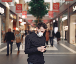 Masked man texting in the marketplace